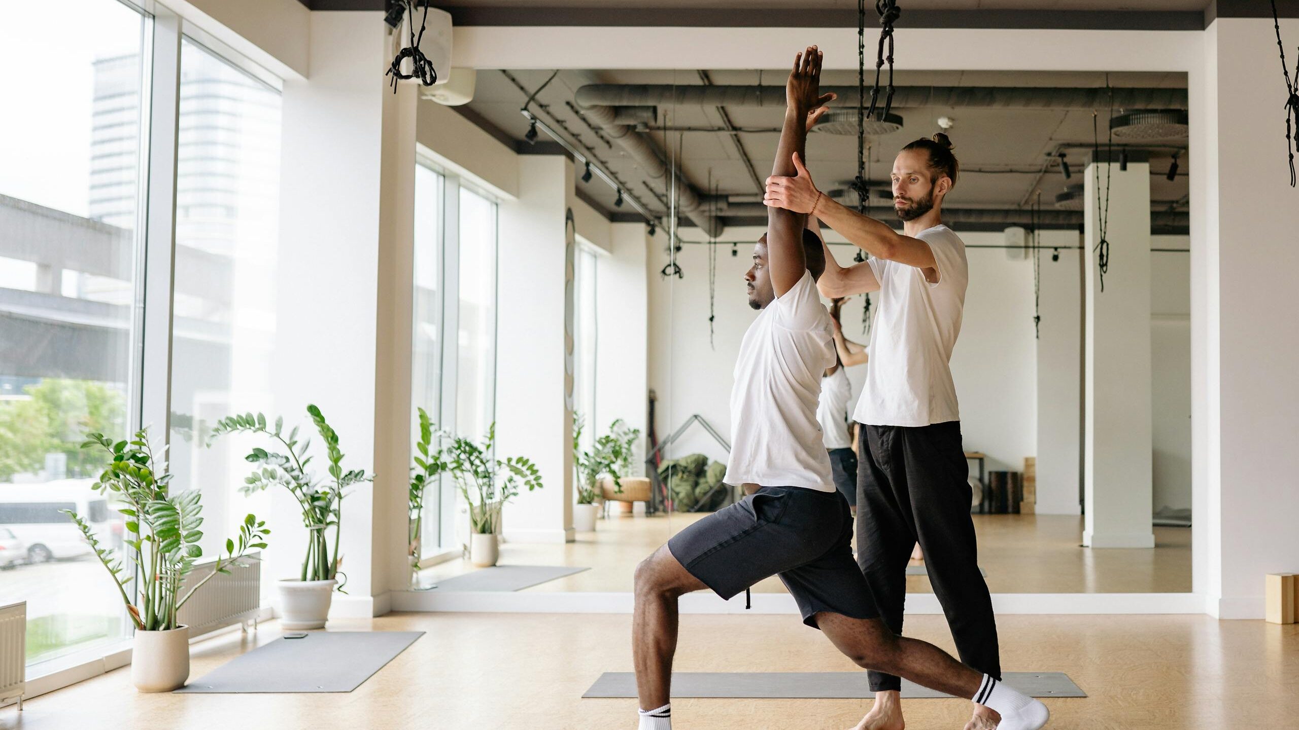 A Yoga Instructor Teaching a Student in a Yoga Class