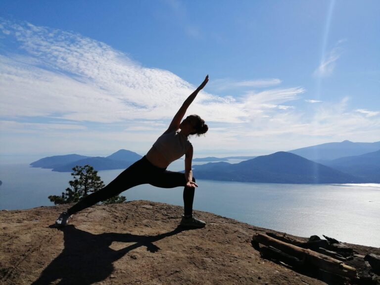 Ily Ponce practicing hatha yoga outdoors overlooking the ocean in Vancouver, Omvana Wellbeing